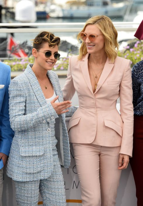 mujer con saco rosa y mujer con traje azul cuelo