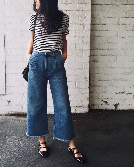 mujer con pantalón de mezclilla y camisa de rayas 