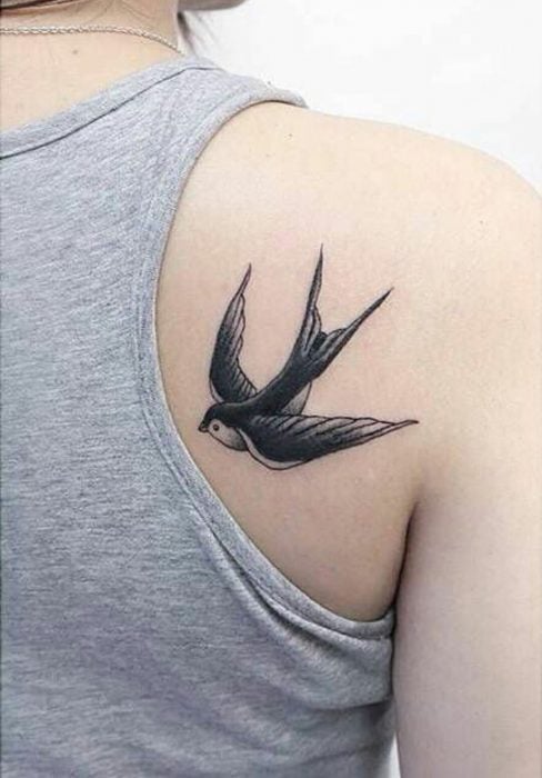 tatuaje de golondrina en espalda de mujer 