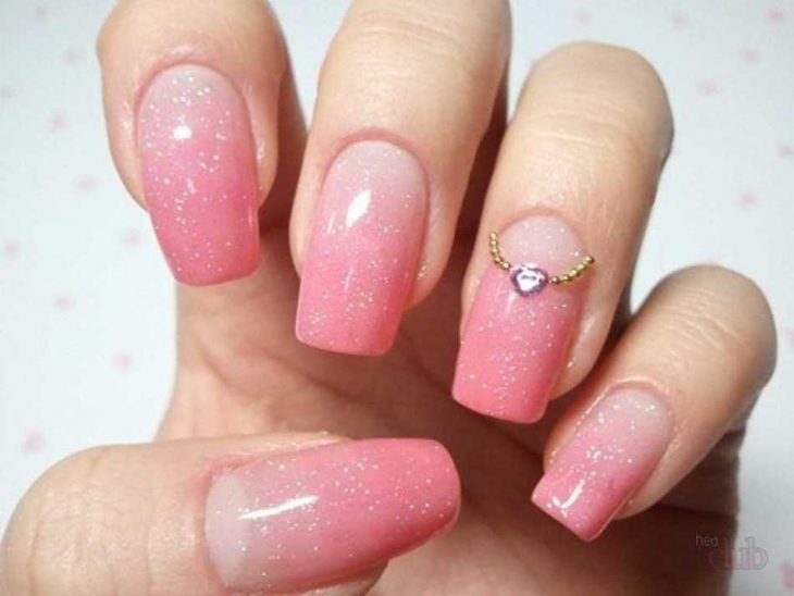 manos de mujer con uñas rosas 