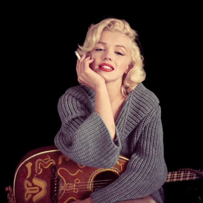 Marilyn Monroe sosteniendo un cigarro y una guitarra 