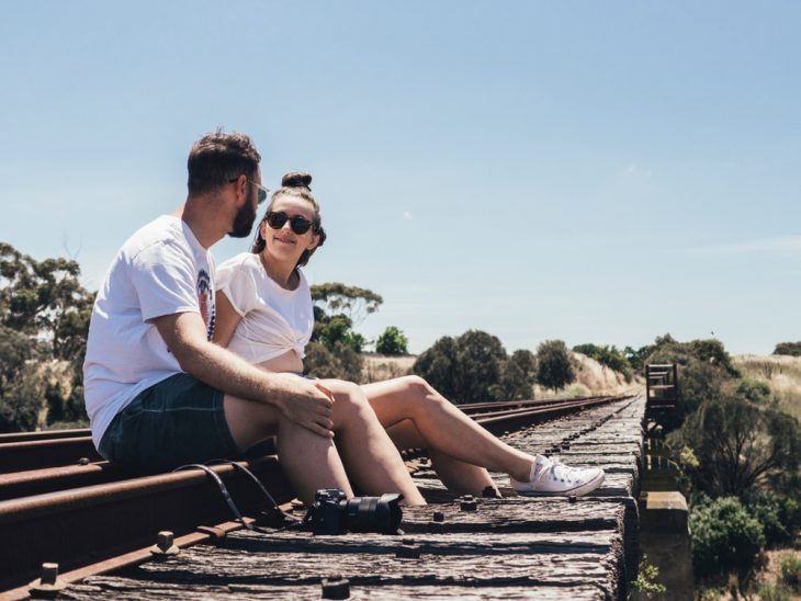 pareja de novios sentados en unas vías