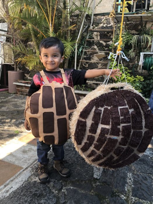 Niño vestido de concha con una concha de piñata