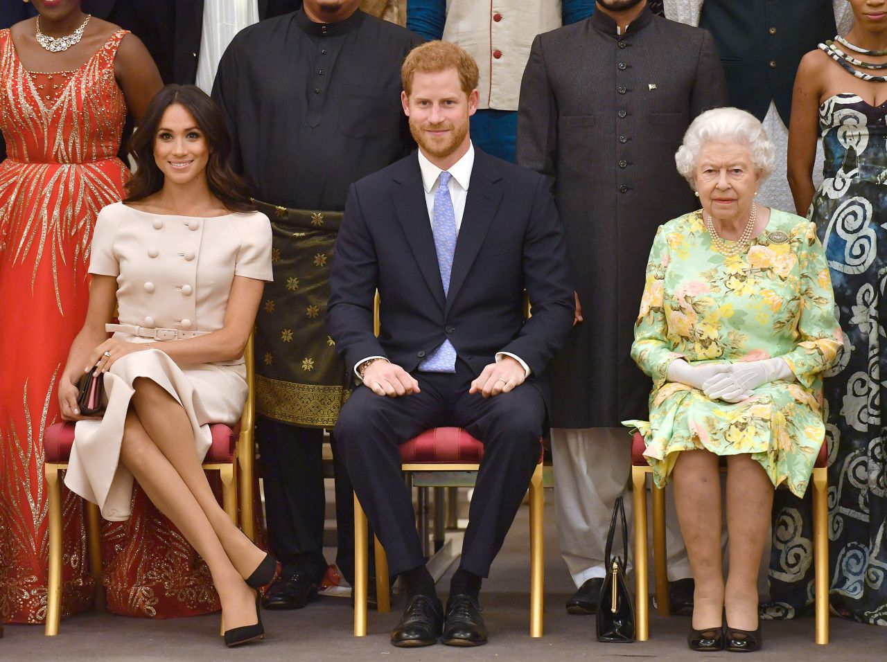 Meghan Markle con las piernas cruzadas frente a la reina