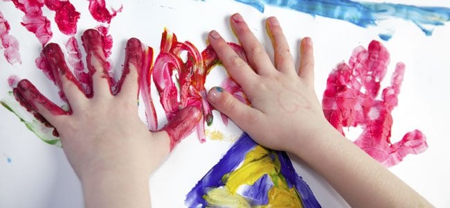 manos de niño llenas de pintura 