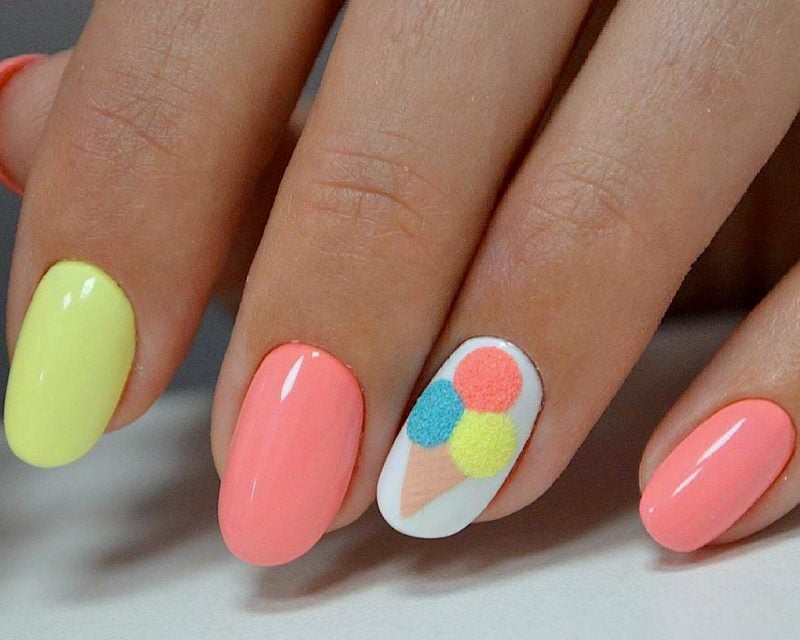 Uñas cortas en color rosa salmón con un helado en medio