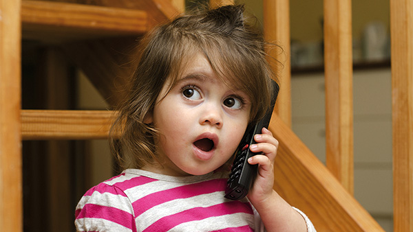 Niña hablando por telefono con rostro sorprendido 