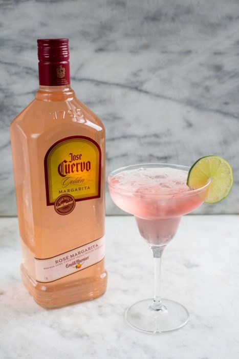 botella de margaritas con copa de limonada rosa