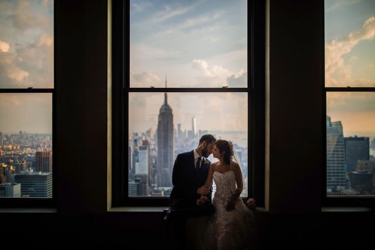 Pareja de novios en un callejón besándose durante una sesión de fotos el día de su boda 