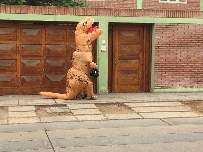 Papá e hijo caminando por la calle vestidos de dinosaurios