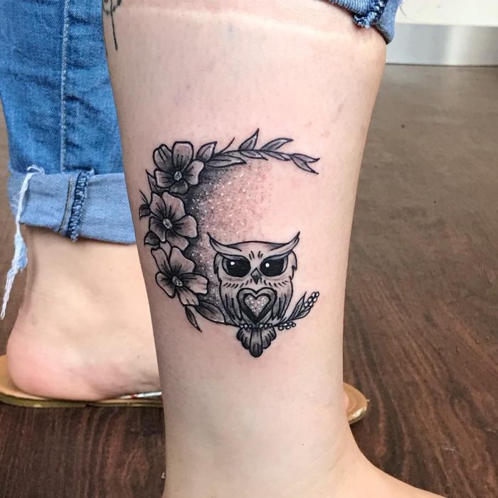 Tatuaje de un buho sentado sobre una luna