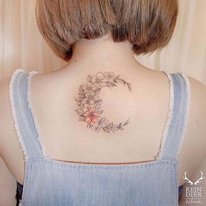 Tatuaje de una luna en la espalda hecha con flores
