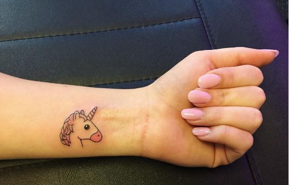 Chica con un tatuaje de unicornio en la muñeca