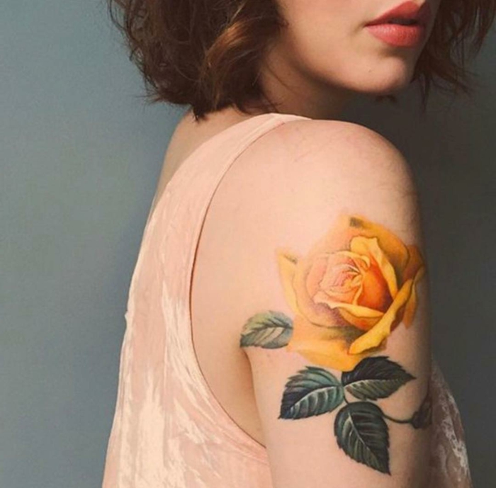 Chica mostrando su tatuaje de una rosa en el hombro