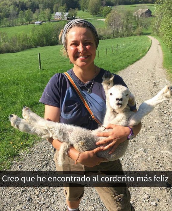 Un corderito feliz en brazos de una chica