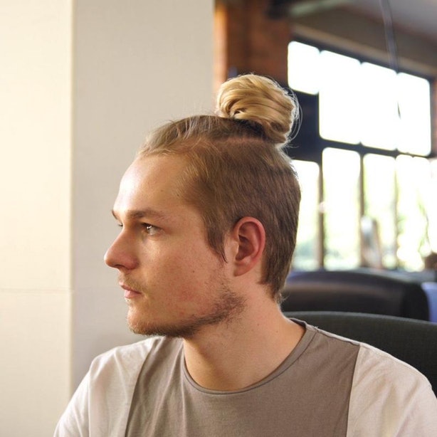 hombre rubio de perfil con chongo man bun 