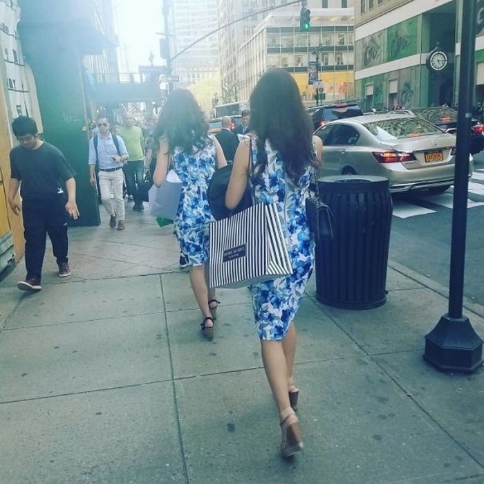 Dos mujeres desconocidas caminando en la calle con el mismo vestido