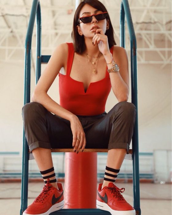 mujer sentada con pantalon tenis rojos y blusa roja 