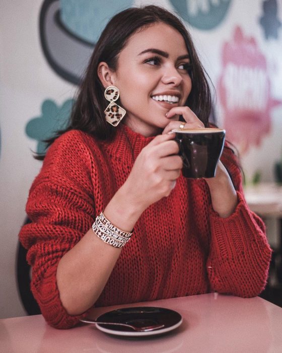 mujer con sueter rojo y taza de café 