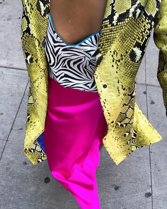 mujer con falda rosa y saco amarillo blusa de cebra