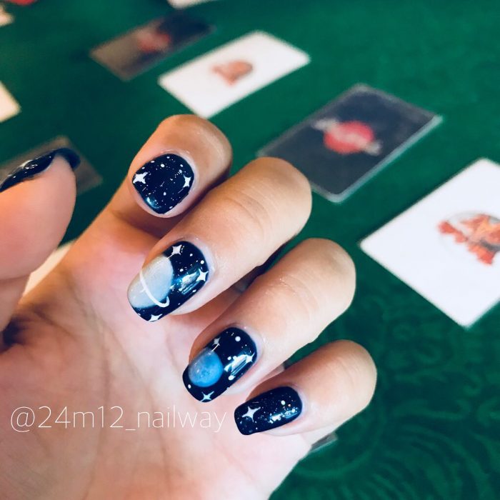 Manos con uñas negras de galaxia 