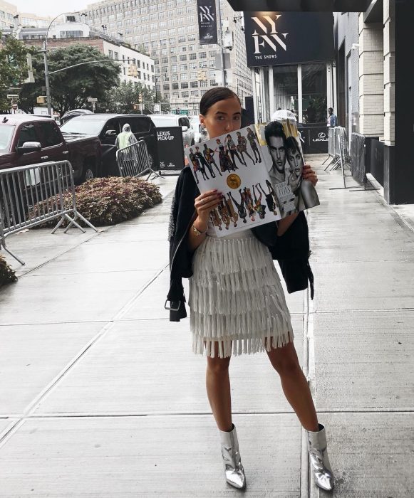 mujer con falda de flecos blanca y botines blancos 