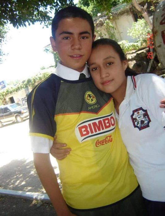 chico con camisa de futbol y niña con uniforme 