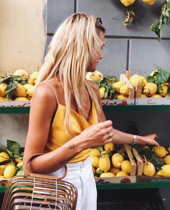 chica comprando limones 