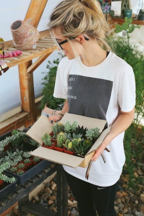 chica cargando plantas 