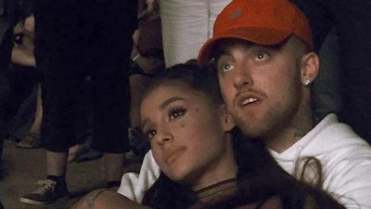 ariana grande chica abrazada por chico rubio con gorra roja