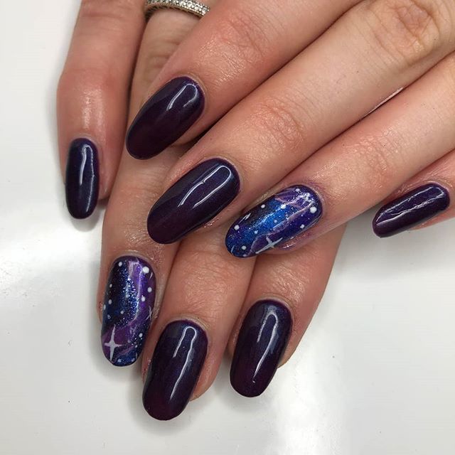 Manos con uñas negras de galaxia 