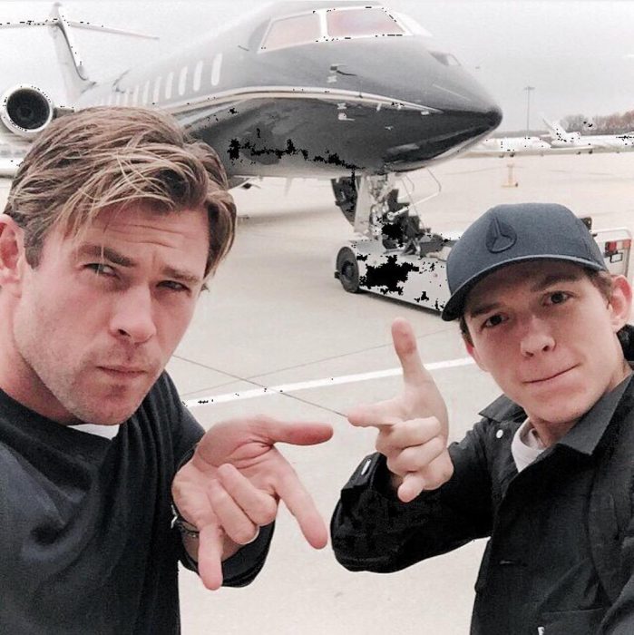 hombres junto a avión haciendo seña de hombre araña