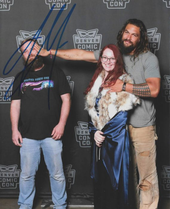 Jason Momoa alejando a un fan