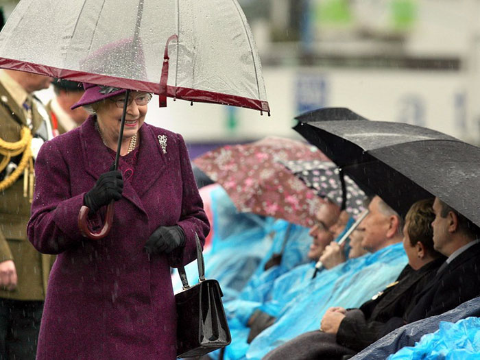 Reina Isabel II combinando sus paraguas con sus outfits de diferentes colores 