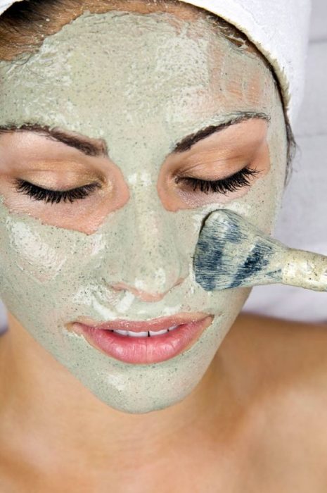 Chica aplicandose una mascarilla natural en el rostro 