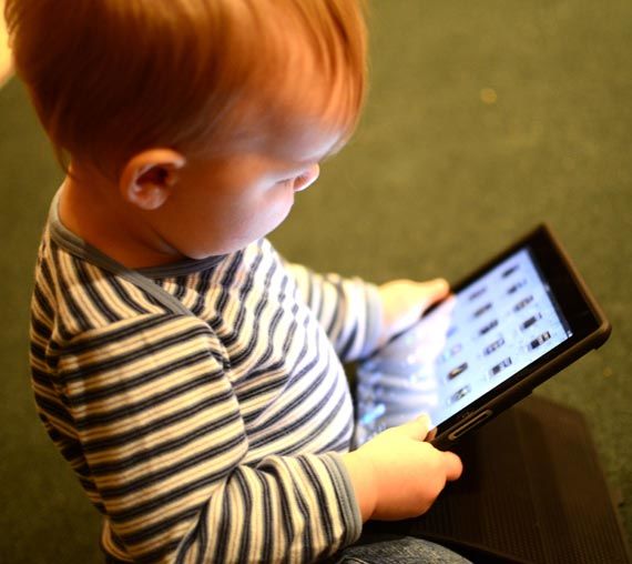 Niña de dos años sosteniendo una tabler