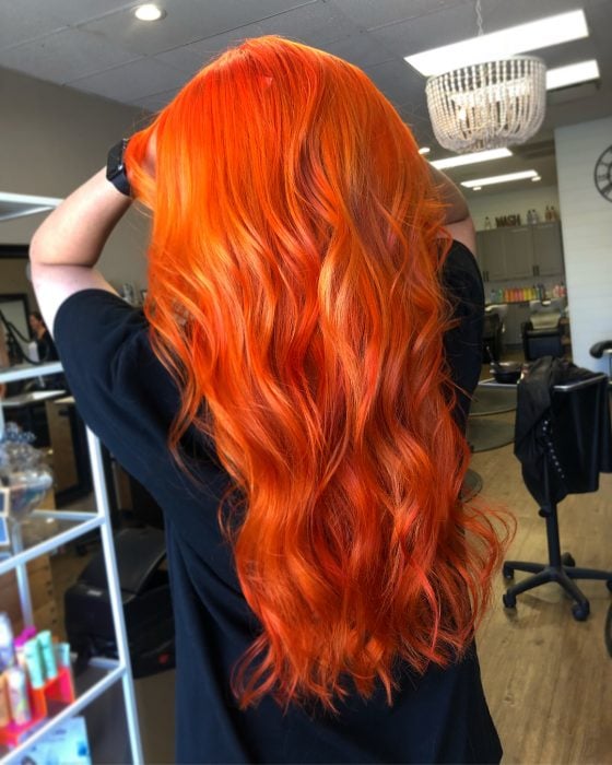 Chica con el cabello largo y teñido de color naranja 