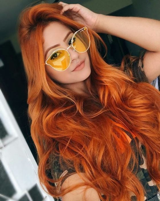 Chica con el cabello largo y teñido de color naranja 