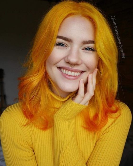 Chica con el cabello largo y teñido de color naranja 