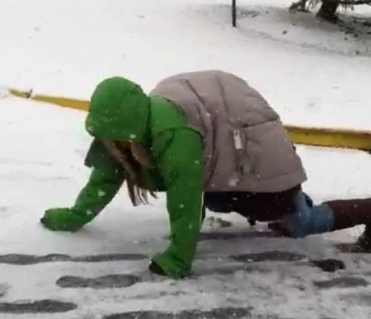 Mujer gateando en el suelo con una chaqueta que le da el aspecto de una tortuga