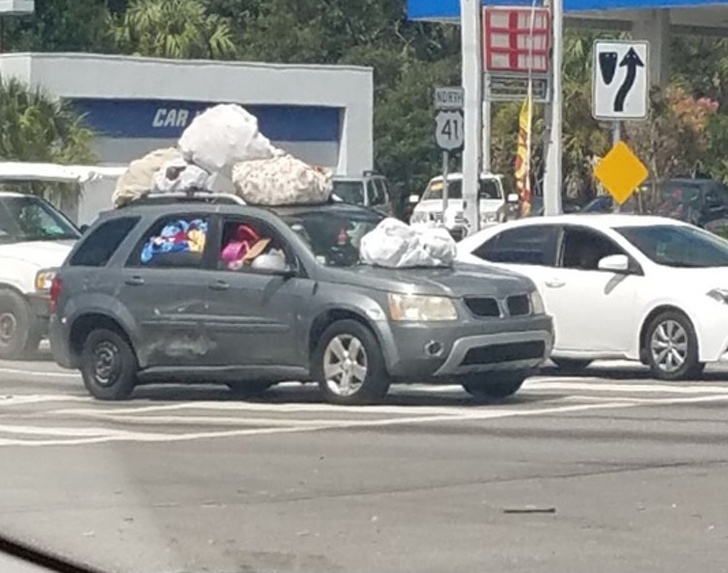 cAMIONETA DE UNA MUJER REPLETA DE COSAS HASTA EN EL TECHO