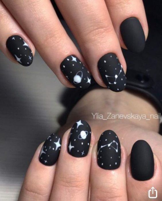 Manos con uñas negras de galaxia 