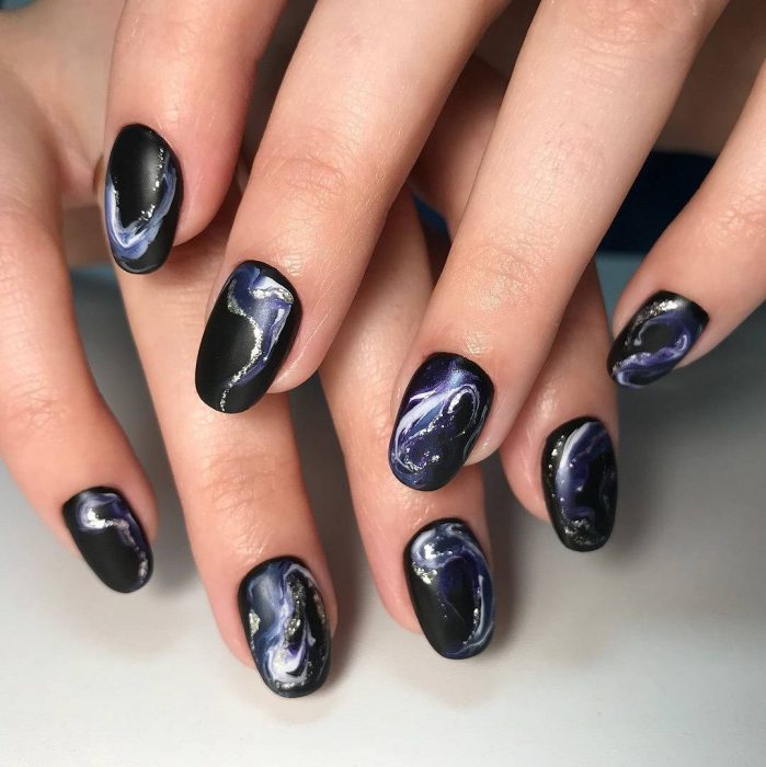 Manos con uñas negras de galaxia 