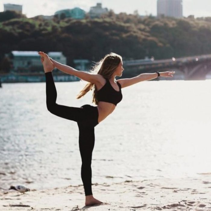 mujer con ropa deportiva haciendo yoga