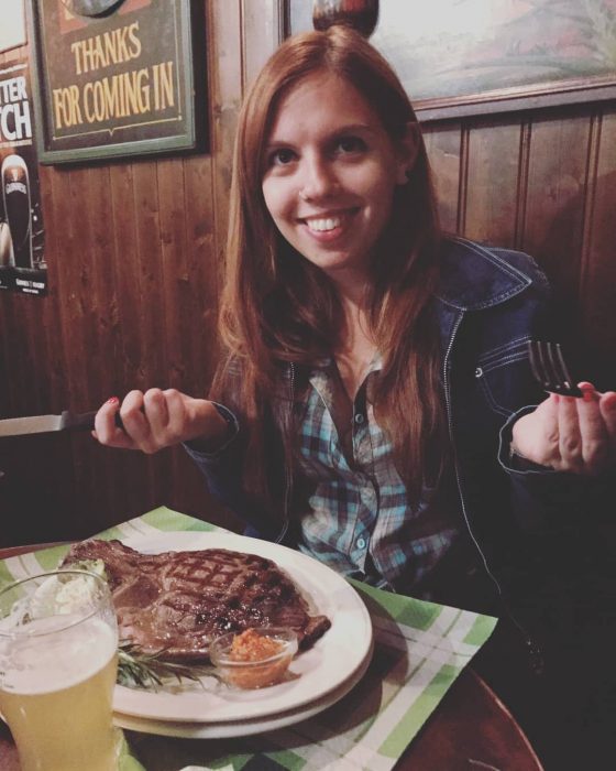 Chica comiendo carne roja