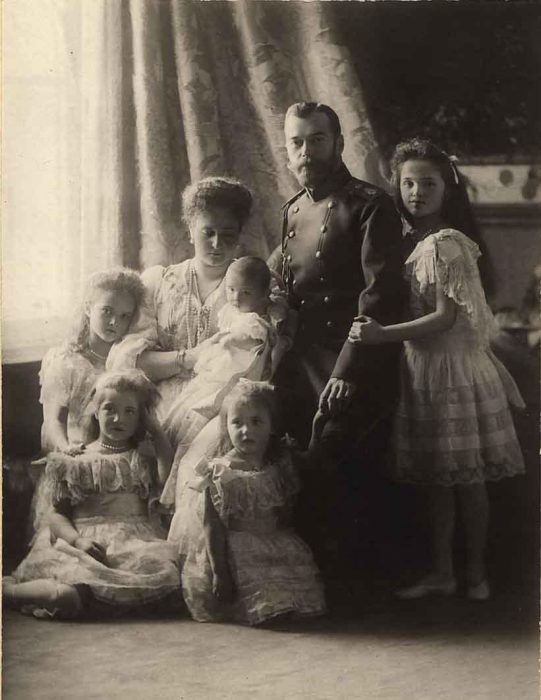 Retrato real de la familia Romanov posando junto a una ventana