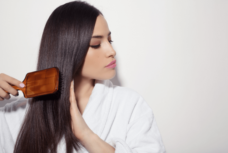 Chica cepillándose el cabello lacio y largo