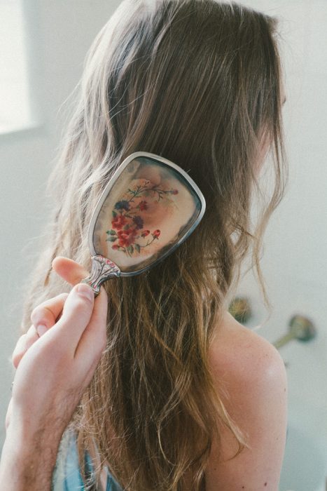 Hombre cepillando el cabello de una chica con un cepillo de flores