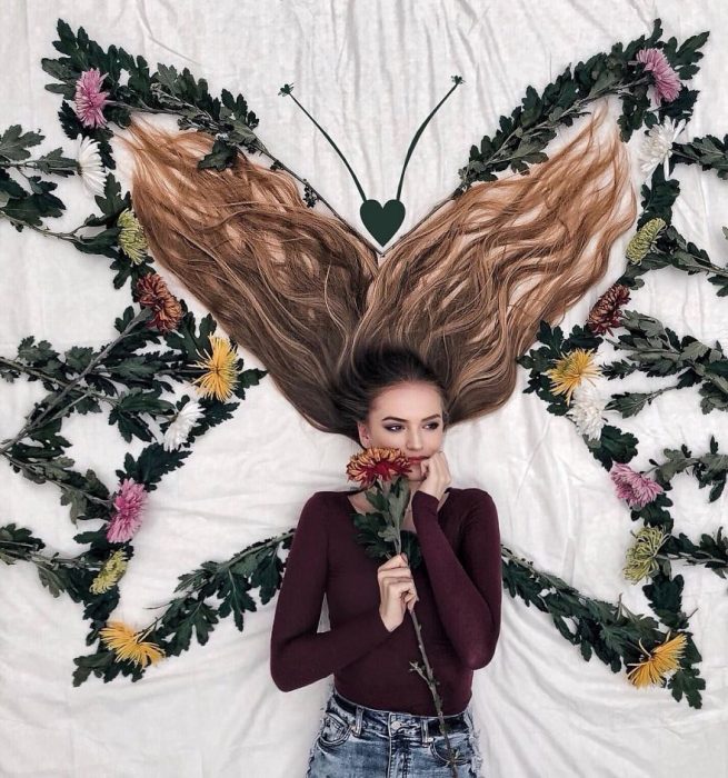 chica formando una mariposa sobre su cabello 