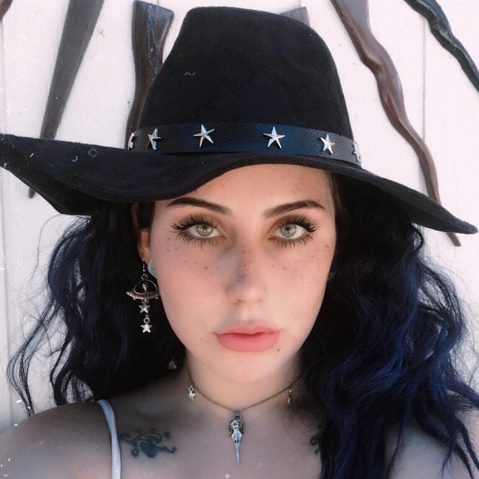 Chica que se parece a Lady Gaga usando un sombrero negro con estrellas 